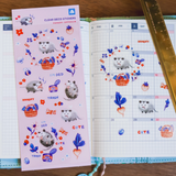 Sticker sheet with cute animal designs on a planner with a ruler for scale.