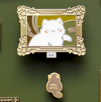 Decorative pin with a cat illustration in an ornate frame on a green background with gold frames.