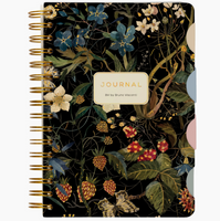 Floral-patterned notebook with a gold spiral binding on a beige background