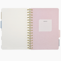 Pink notebook with gold spiral binding on a white background