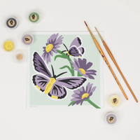 Painting of butterflies and flowers with painting supplies on a white background