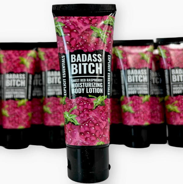 Body lotion tube labeled 'Badass Bitch' with raspberry design on a white background