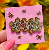 Hand holding a pink card with text and butterfly illustrations against a background of yellow flowers.