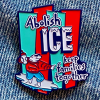 Colorful enamel pin with text and graphic design on denim background