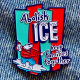 Colorful enamel pin with text and graphic design on denim background