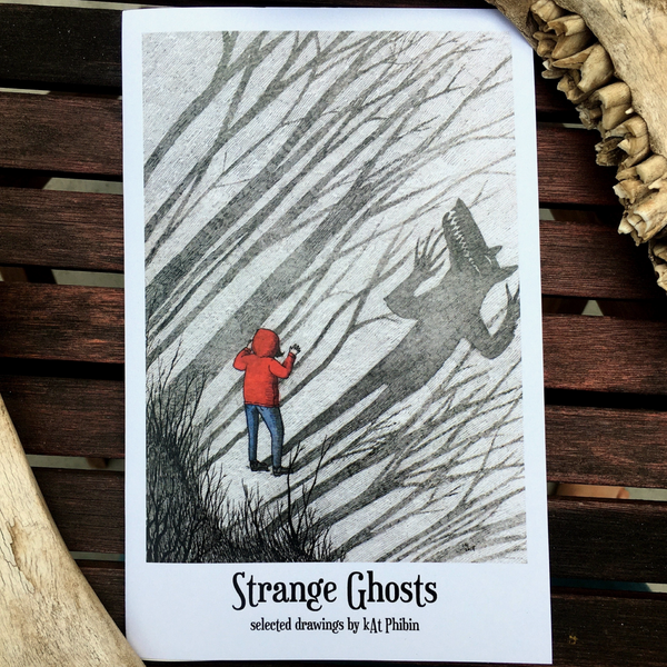 Book cover of 'Strange Ghosts' with a person in a red coat and a shadowy figure on a wooden background