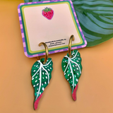 Tropical leaf earrings on a branded card with a leaf background