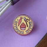 Enamel pin with 'Kitchen Witch' design on a purple background