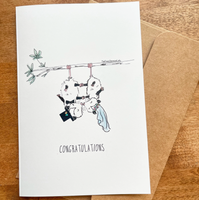 Wedding-themed card with black and white illustration on a wooden surface