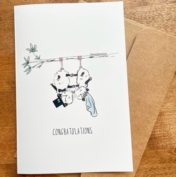 Wedding-themed card with black and white illustration on a wooden surface