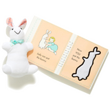 Plush toy rabbit next to an open book with illustrations