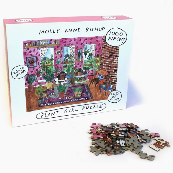Jigsaw puzzle packaging with illustrations of a plant-themed scene and scattered puzzle pieces on a white surface.