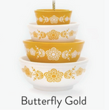 Set of four stacked bowls with gold butterfly design on a white background