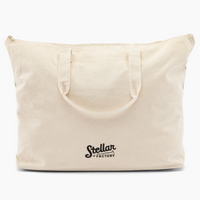 Beige tote bag with 'Stellar Factory' logo on a white background