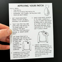 Hand holding a patch application guide against a black background