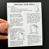 Hand holding a patch application guide against a black background