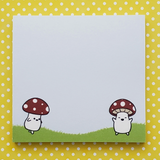 Notepad with cartoon characters under mushrooms on a yellow polka dot background