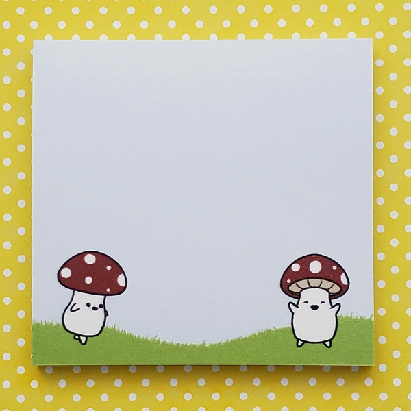 Notepad with cartoon characters under mushrooms on a yellow polka dot background