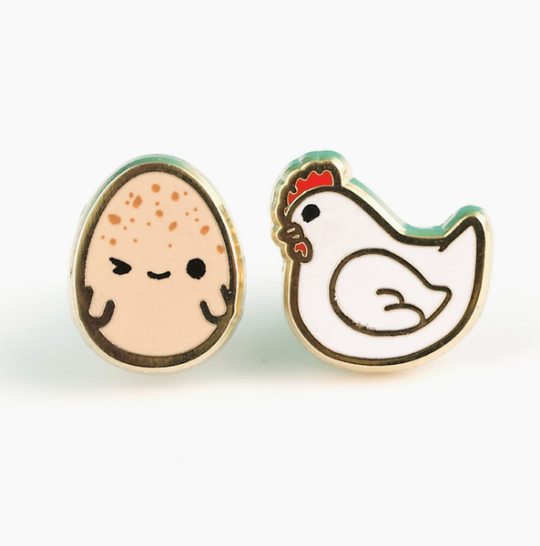 Pair of earrings shaped like a chicken and an egg on a white background