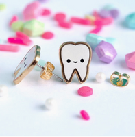 Decorative earrings with a tooth design on a white background with colorful confetti.