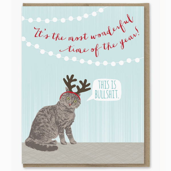 Card with a cat wearing reindeer antlers and text on a light blue background